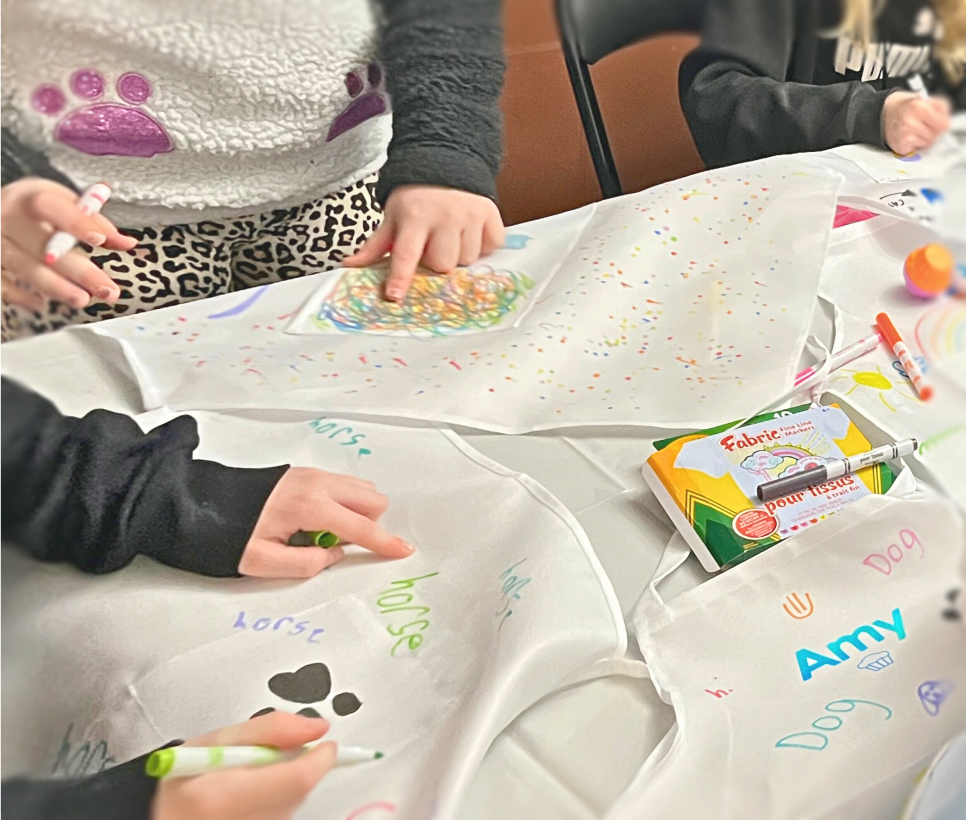 Children decorating aprons as part of The Curious Case of the Sprinkle Snatcher printable escape room for kids birthday party
